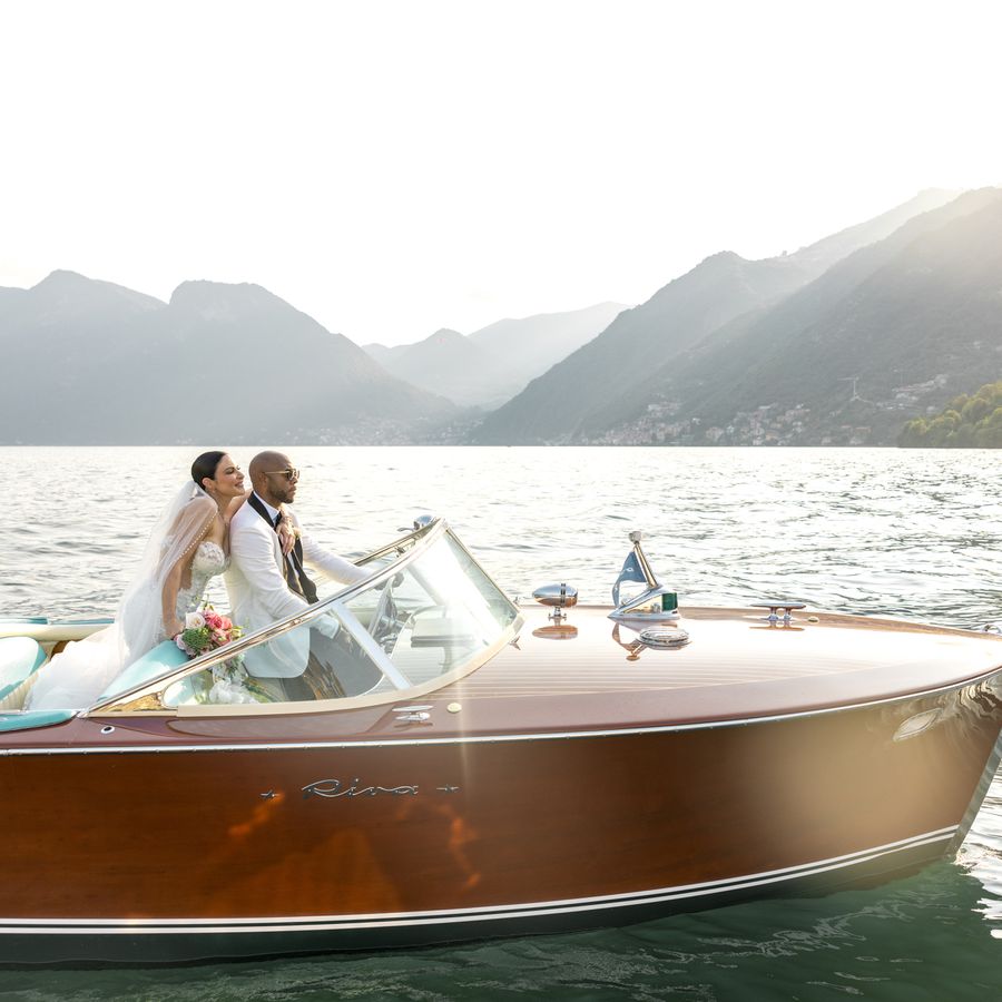 Bride and groom riding a wooden boat on Lake Como