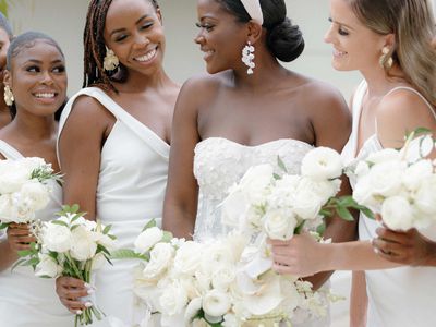 Bride in headband with bouquet and her bridesmaids in white dresses holding bouquets
