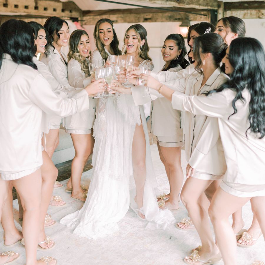 bride and bridesmaids in pajamas toasting with Champagne flutes
