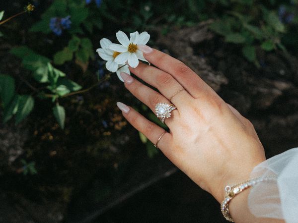 a brides hand holding a flower