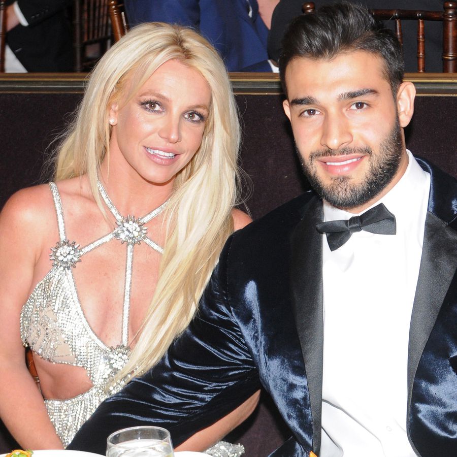 Britney Spears and her husband Sam Asghari pose at a formal dinner event.