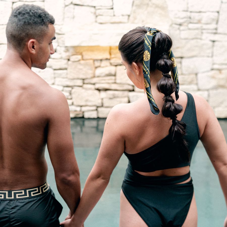 groom and bride wearing black bathing suit and bubble braids hairstyle with silk scarf