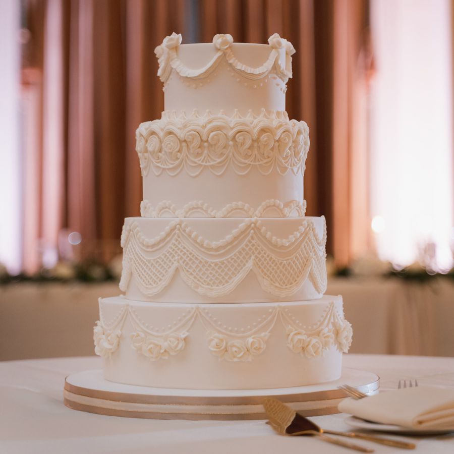 Vintage white wedding cake with piping.