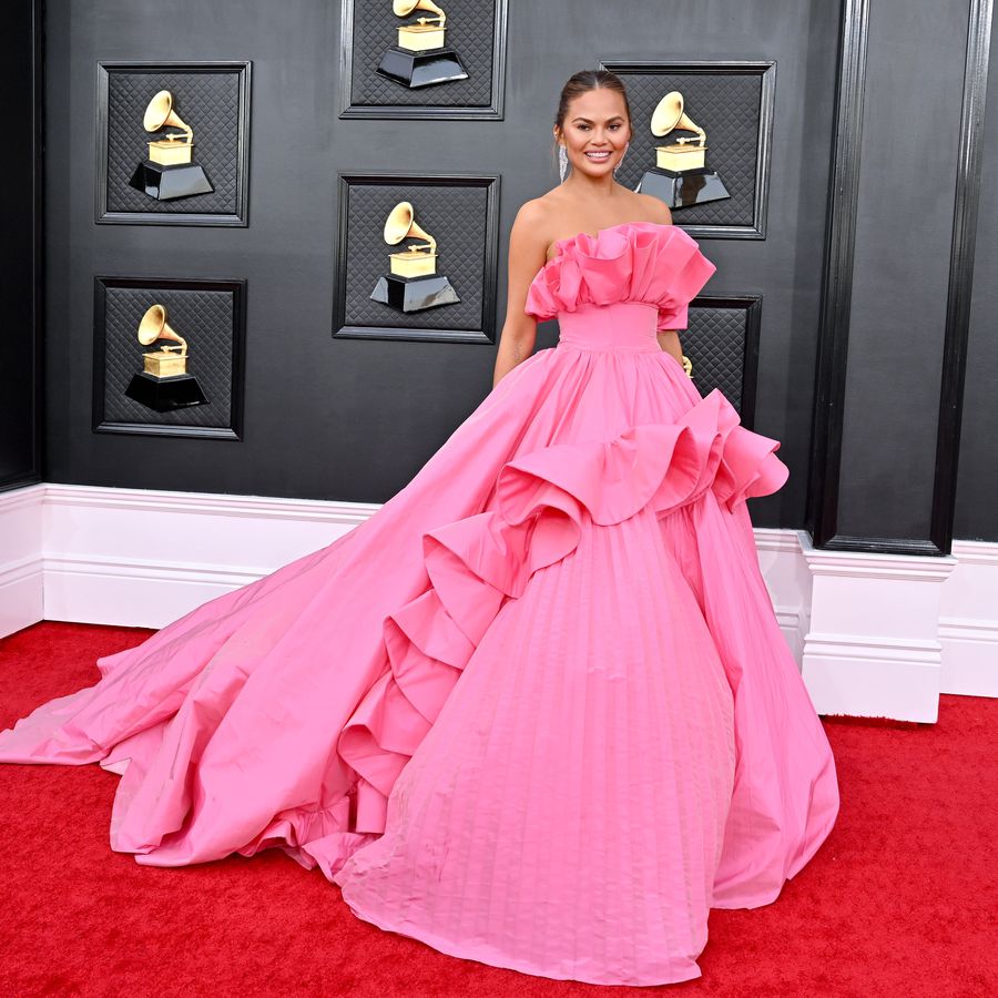 Chrissy Teigen in a pink ruffled ball gown on the red carpet at the Grammy Awards