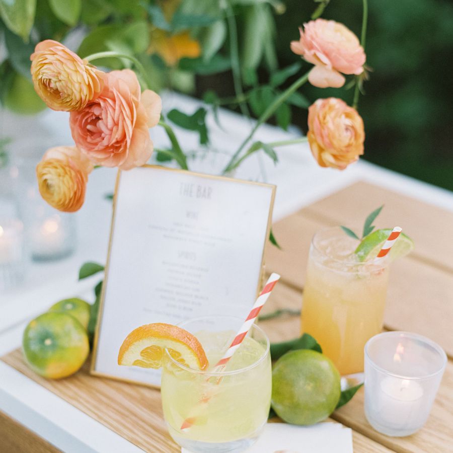 Citrus cocktails with orange flowers and limes at a wedding reception.