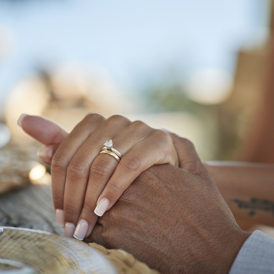 bride and groom hold hands showing off gold engagement ring
