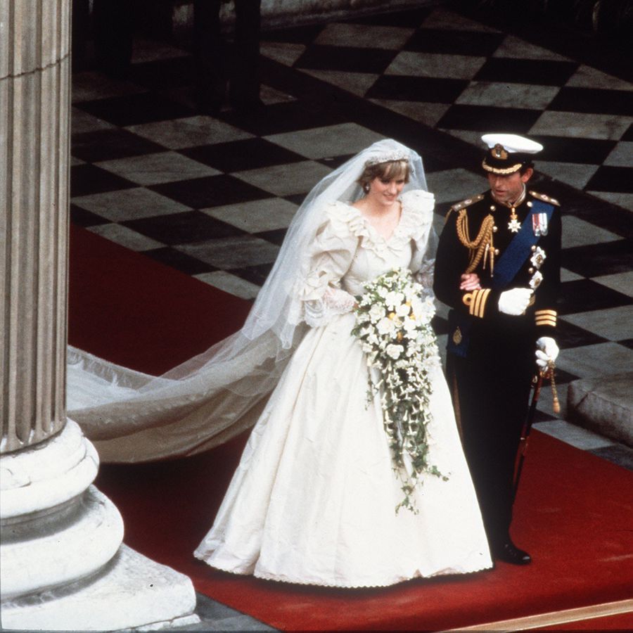 Princess Diana in her ivory taffeta ball gown wedding dress and King Charles linking arms on wedding day