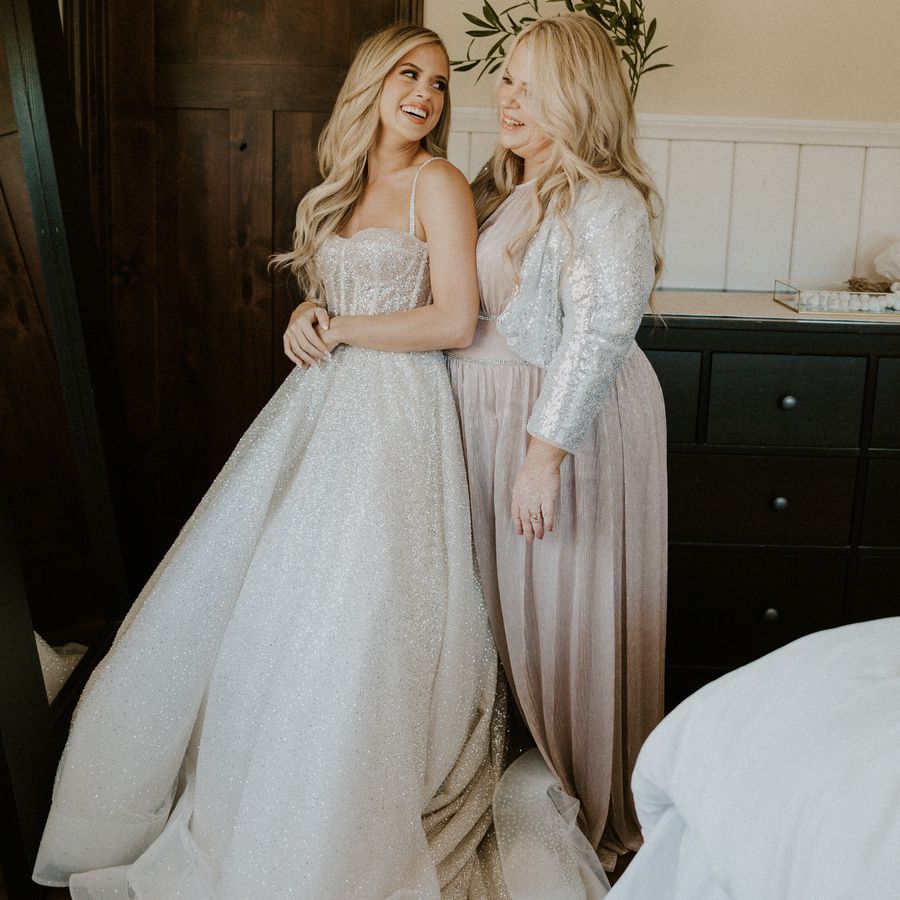 Bride and mother of the bride posing in a room