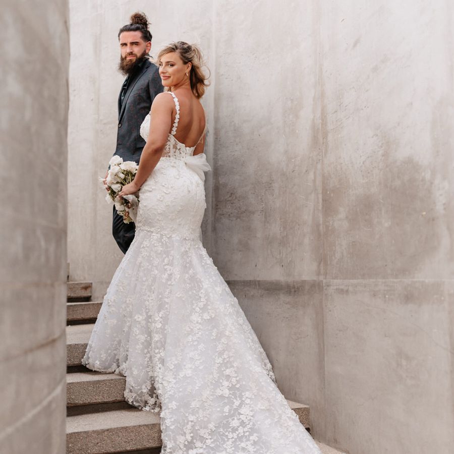 New York Jets tight end Tyler Conklin and bride posing on wedding day against cement wall