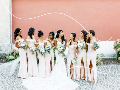Bridesmaids in Pink Off-the-Shoulder Gowns with Bride in Wedding Dress Against Pink Wall